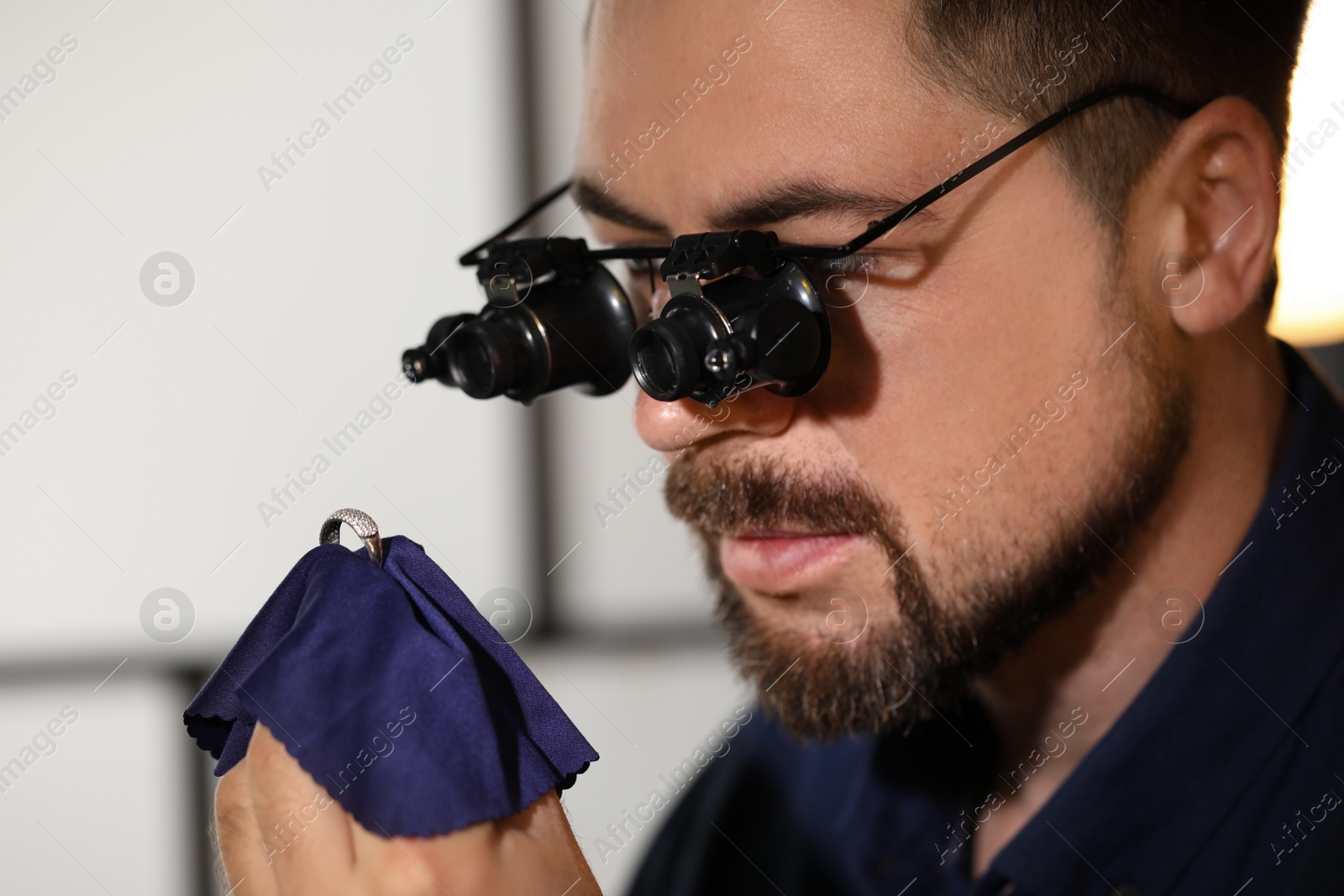 Photo of Jeweler working with ring on blurred background, closeup