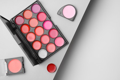 Photo of Flat lay composition with cream lipstick palettes on color background, space for text. Professional cosmetic product