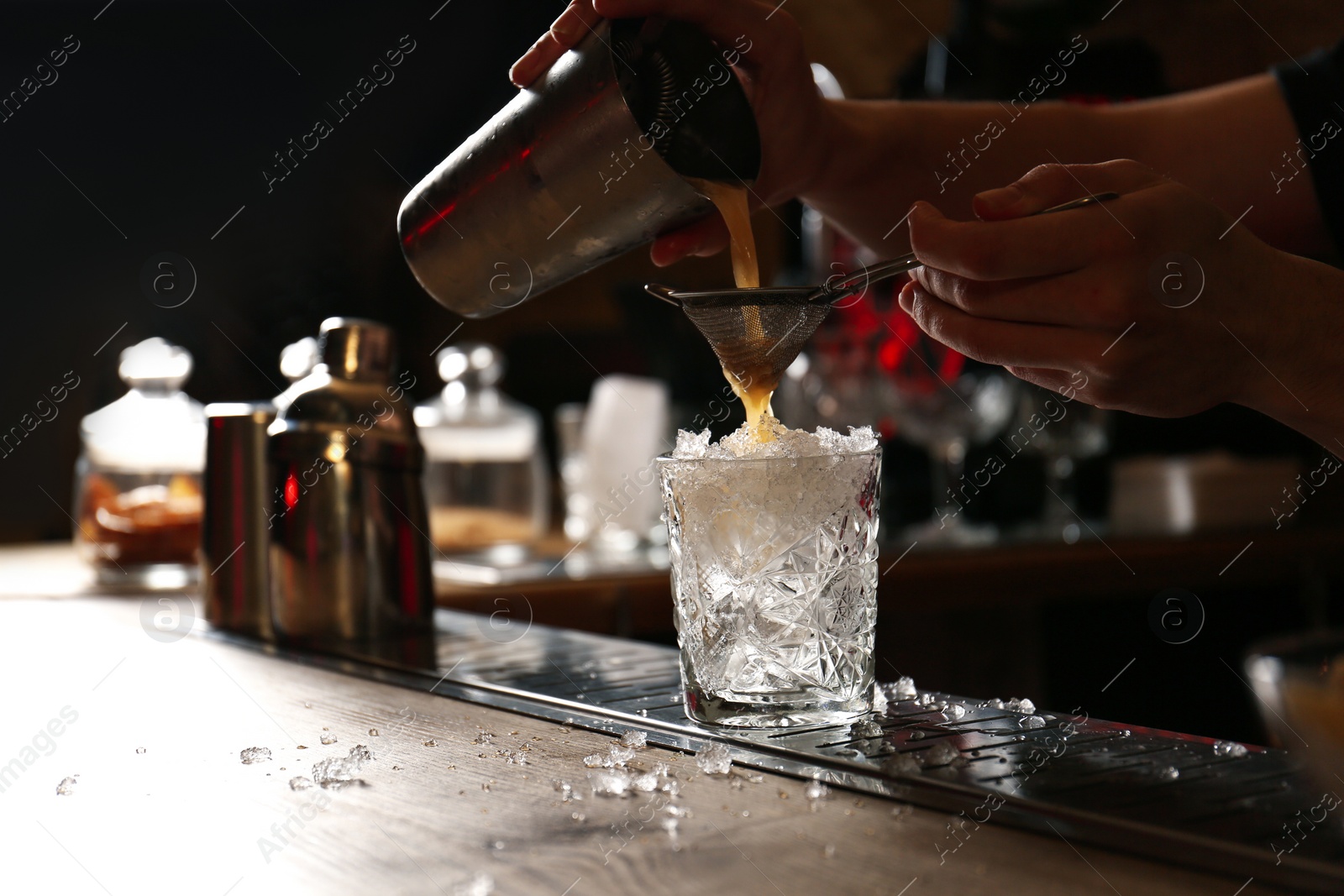 Photo of Bartender preparing fresh alcoholic cocktail at bar counter, closeup