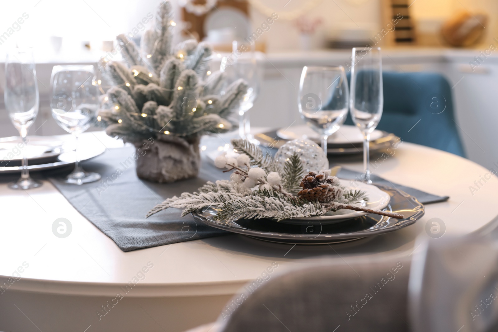 Photo of Table with set of dishware and beautiful Christmas decor in kitchen. Interior design