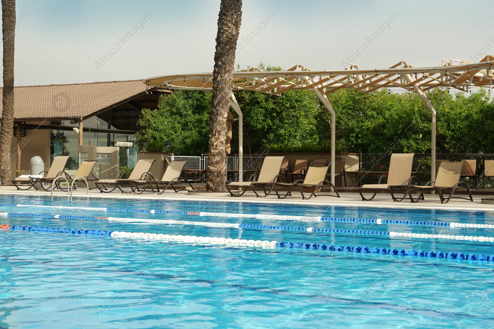 Photo of Swimming pool and sunbeds at luxury resort