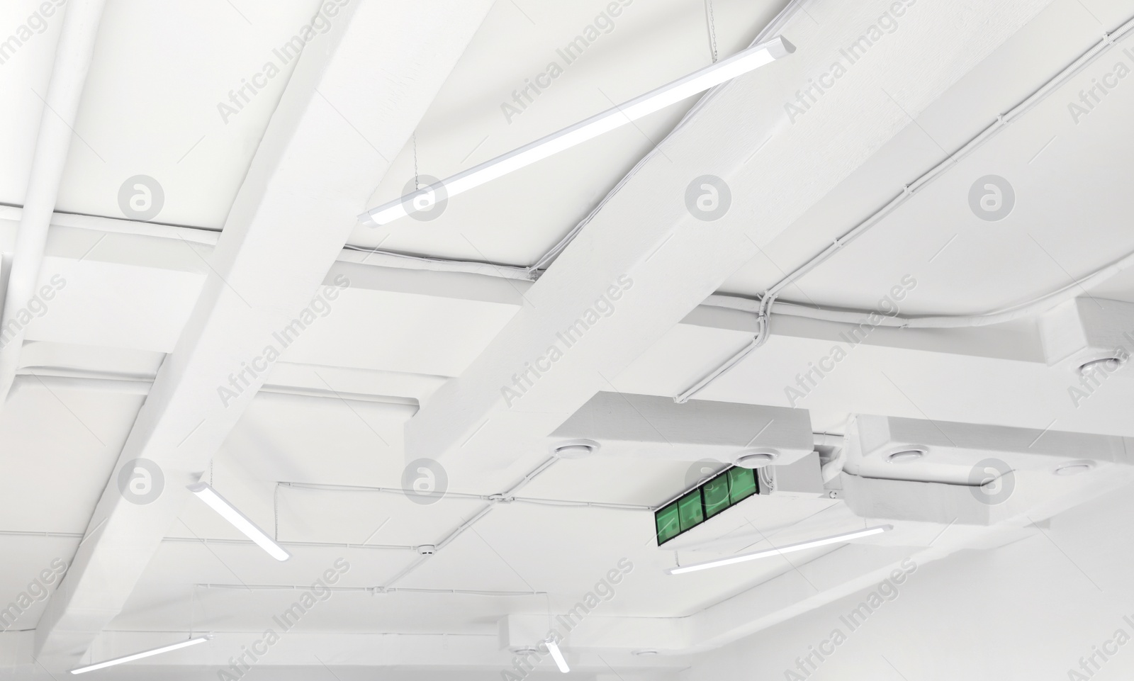 Photo of White ceiling with modern lighting in room, low angle view