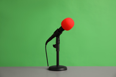 Photo of Microphone on table against green background. Journalist's equipment