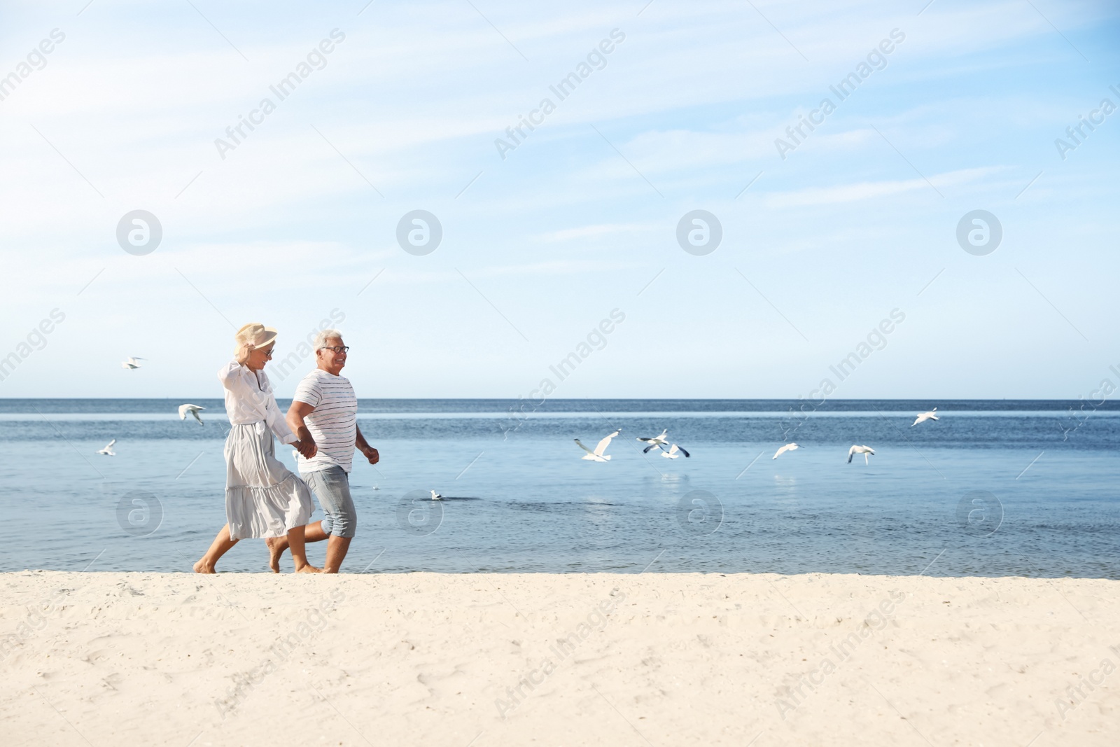 Photo of Happy mature couple spending time together on sea beach