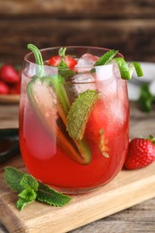 Spicy strawberry cocktail with jalapeno and mint on wooden table, closeup