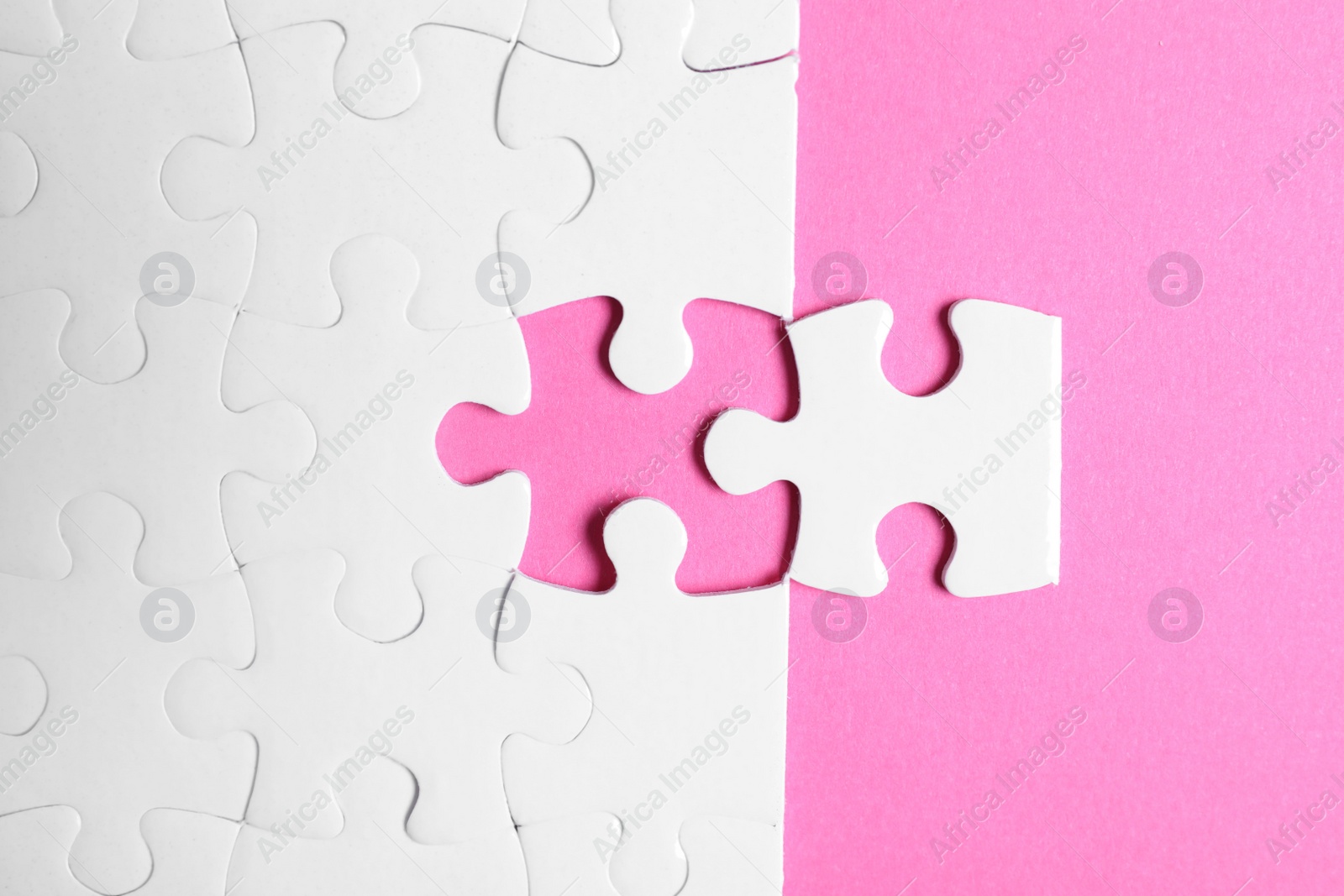 Photo of Blank white puzzle with separated piece on pink background, flat lay