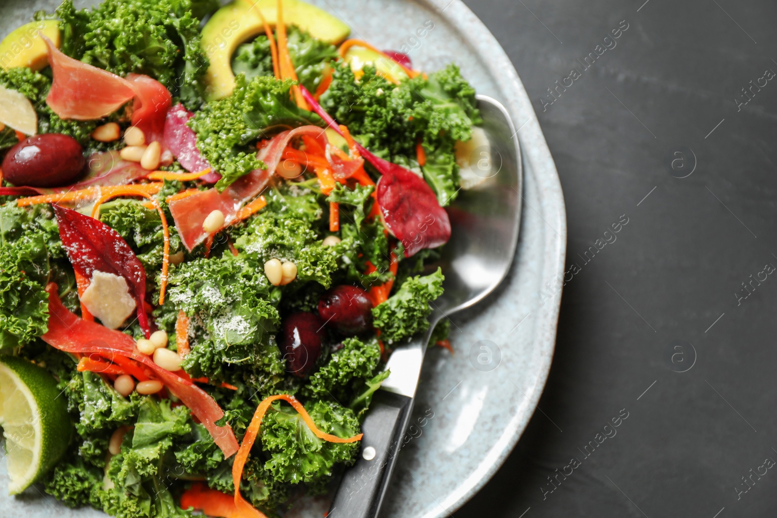 Photo of Tasty fresh kale salad on grey table, closeup