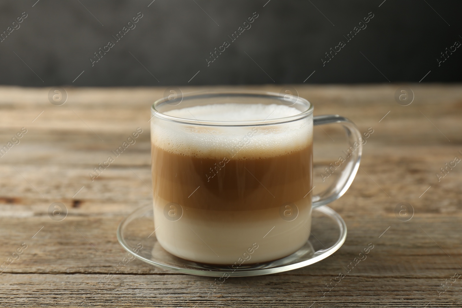 Photo of Aromatic coffee in glass cup on wooden table