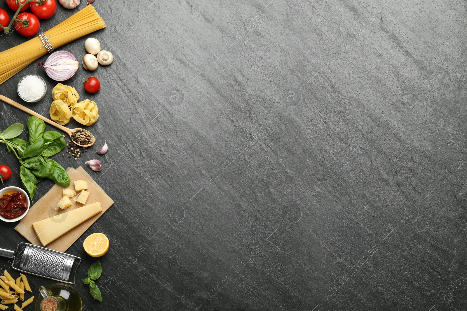 Photo of Different types of pasta, spices, garter and products on dark textured table, flat lay. Space for text
