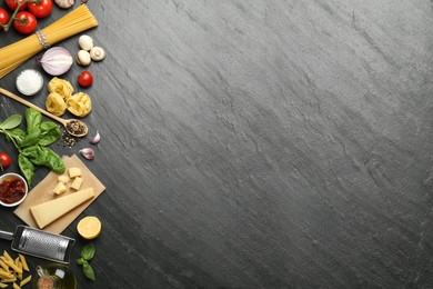 Different types of pasta, spices, garter and products on dark textured table, flat lay. Space for text