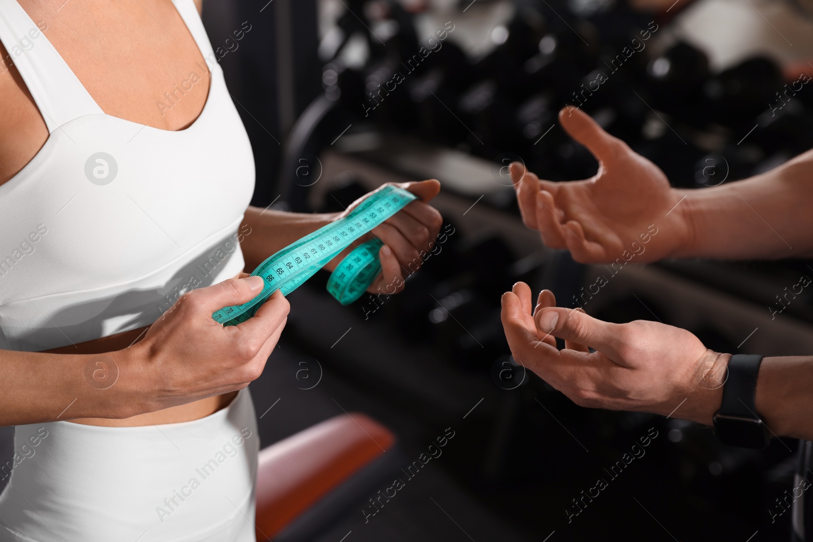 Photo of Trainer having discussion with woman in gym, closeup