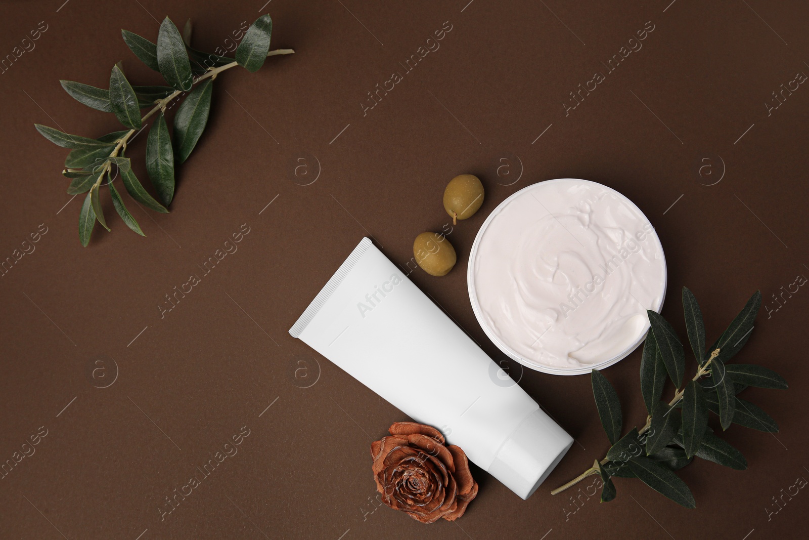 Photo of Flat lay composition with cosmetic products and olives on brown background