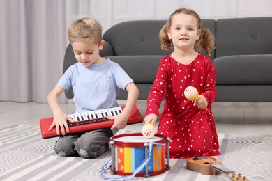 Photo of Little children playing toy musical instruments at home