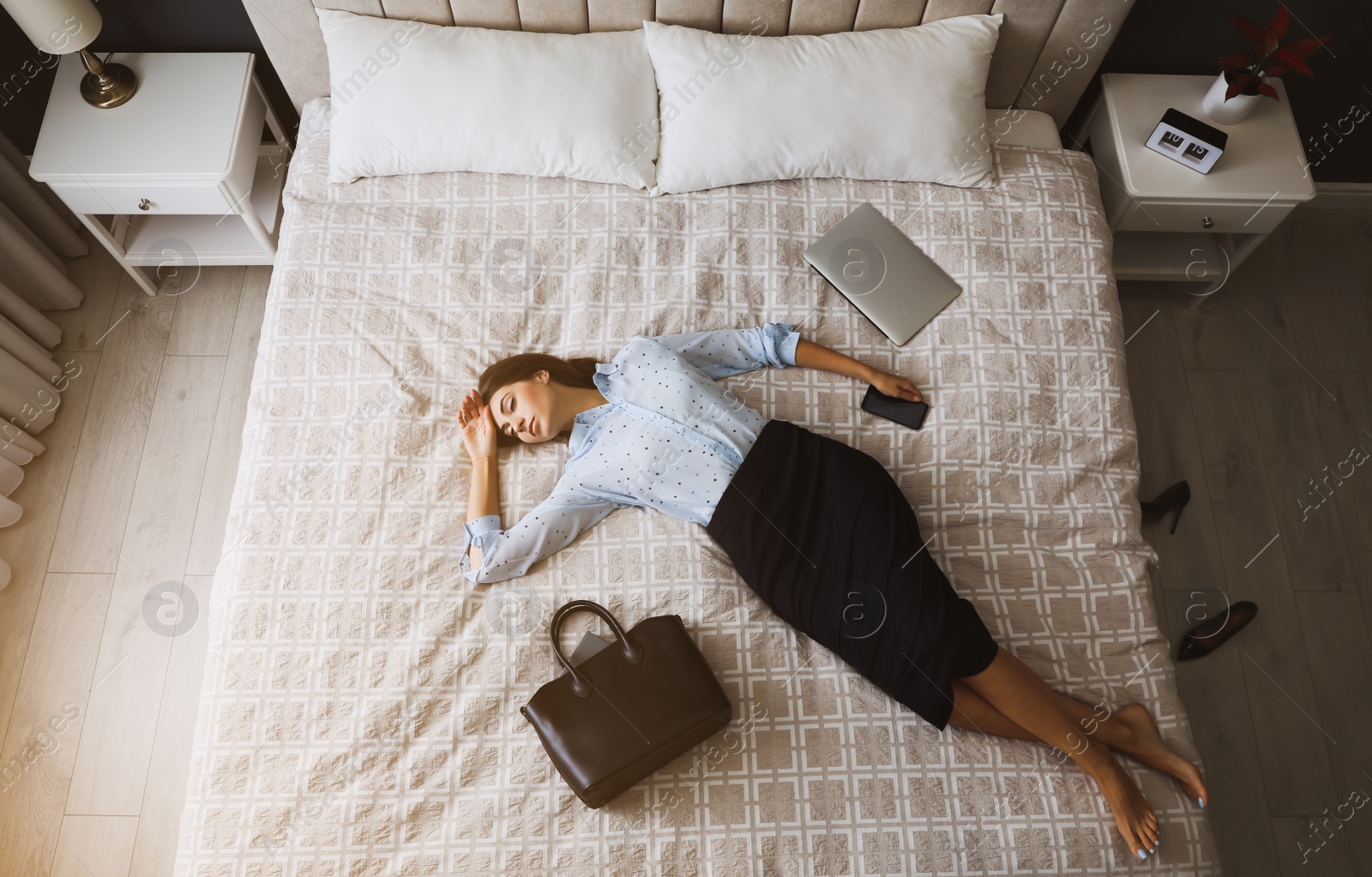 Photo of Exhausted businesswoman in office wear sleeping on bed at home after work, above view