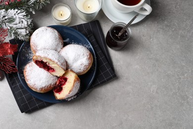 Photo of Delicious sweet buns with jam, cup of tea and decor on gray table, flat lay. Space for text