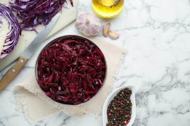 Photo of Tasty red cabbage sauerkraut and ingredients on white marble table, flat lay. Space for text