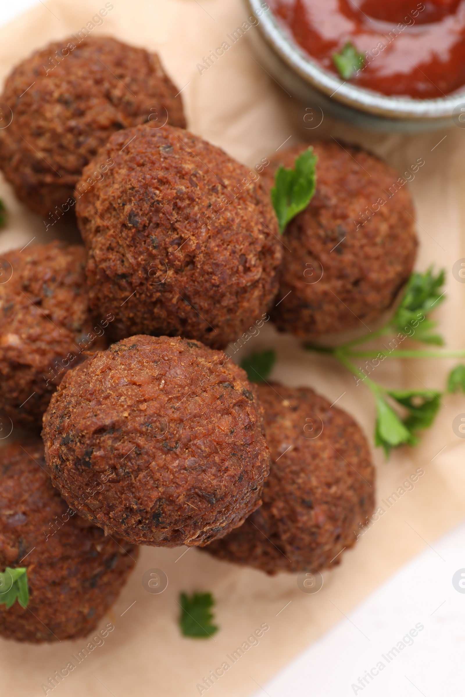 Photo of Vegan meat products. Delicious falafel balls and parsley on table, flat lay