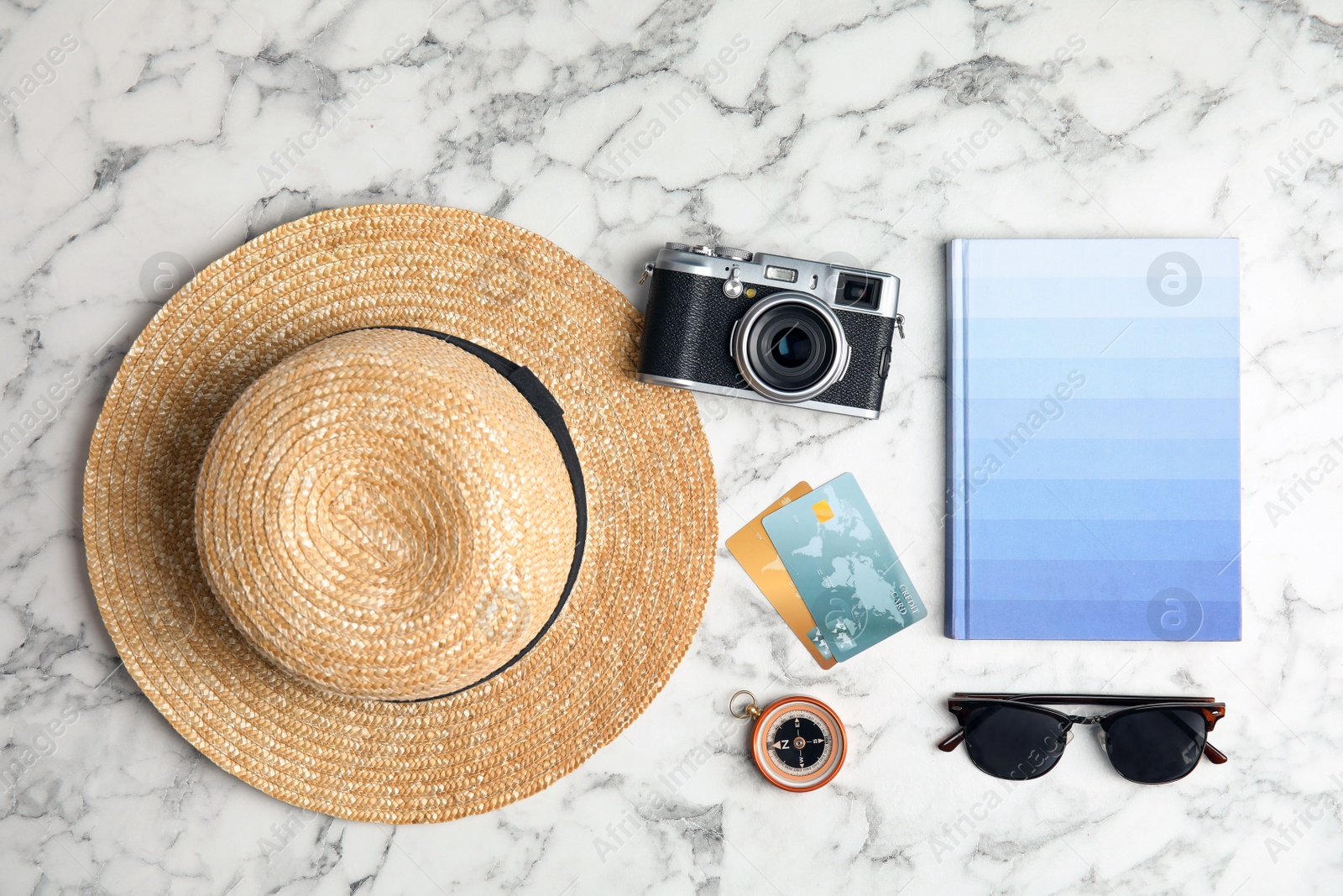 Photo of Flat lay composition with tourist items and notebook on marble background. Travel agency