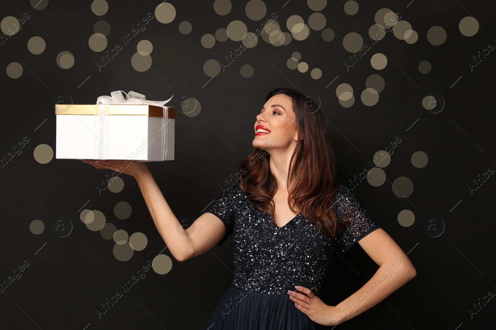 Photo of Beautiful woman with Christmas gift on black background