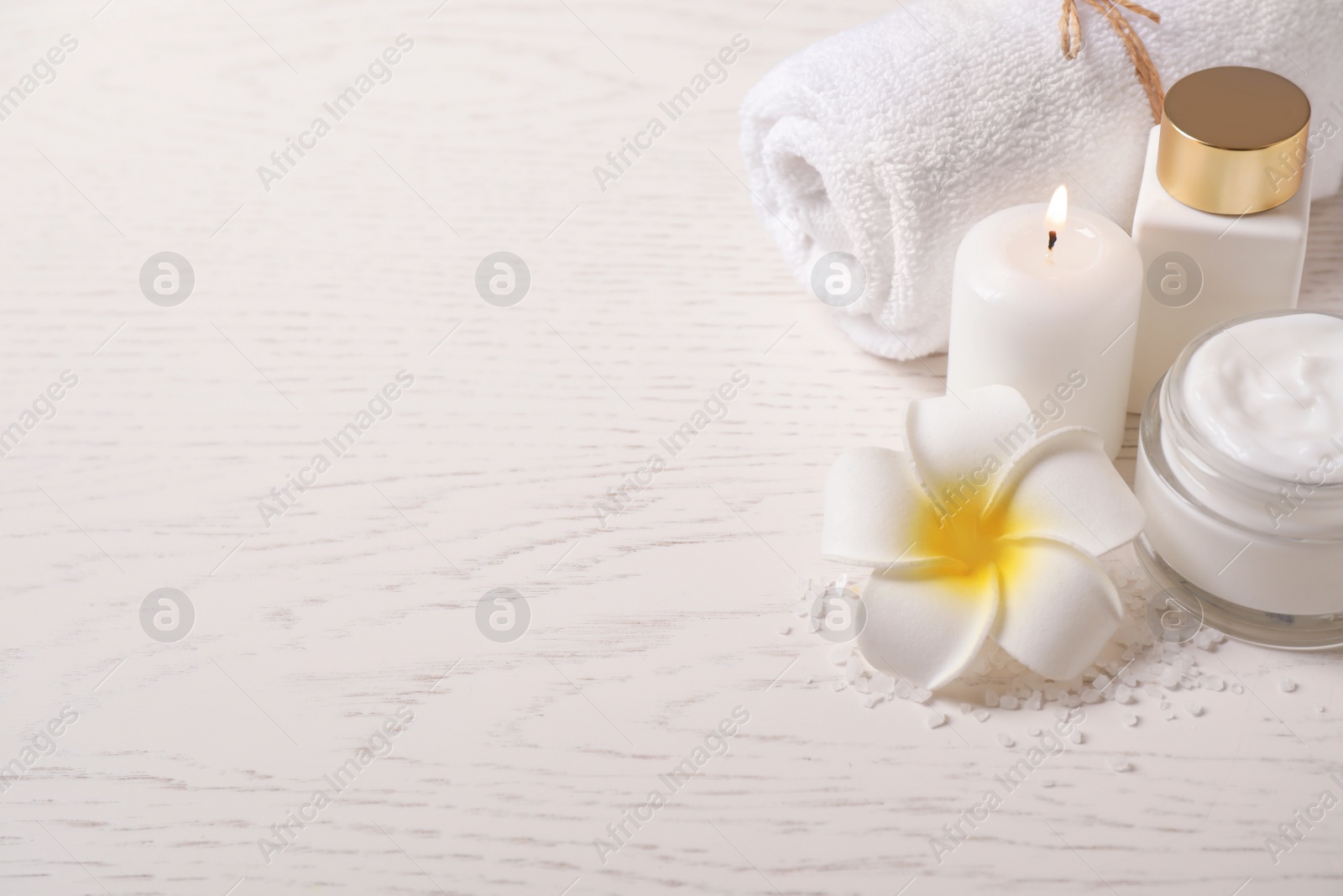 Photo of Composition with cream and burning candles on white wooden table, space for text. Spa treatment