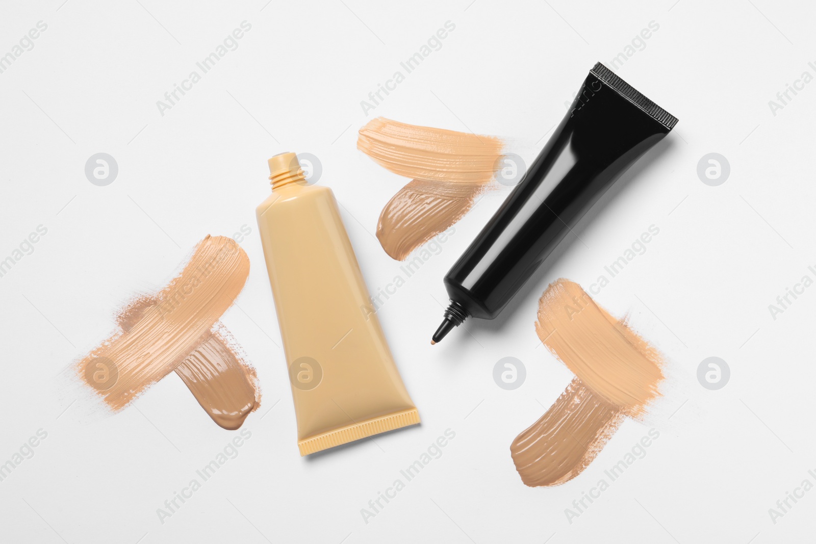 Photo of Liquid foundations and swatches on white background, flat lay