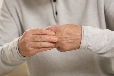 Senior man suffering from pain in hand, closeup. Rheumatism symptom