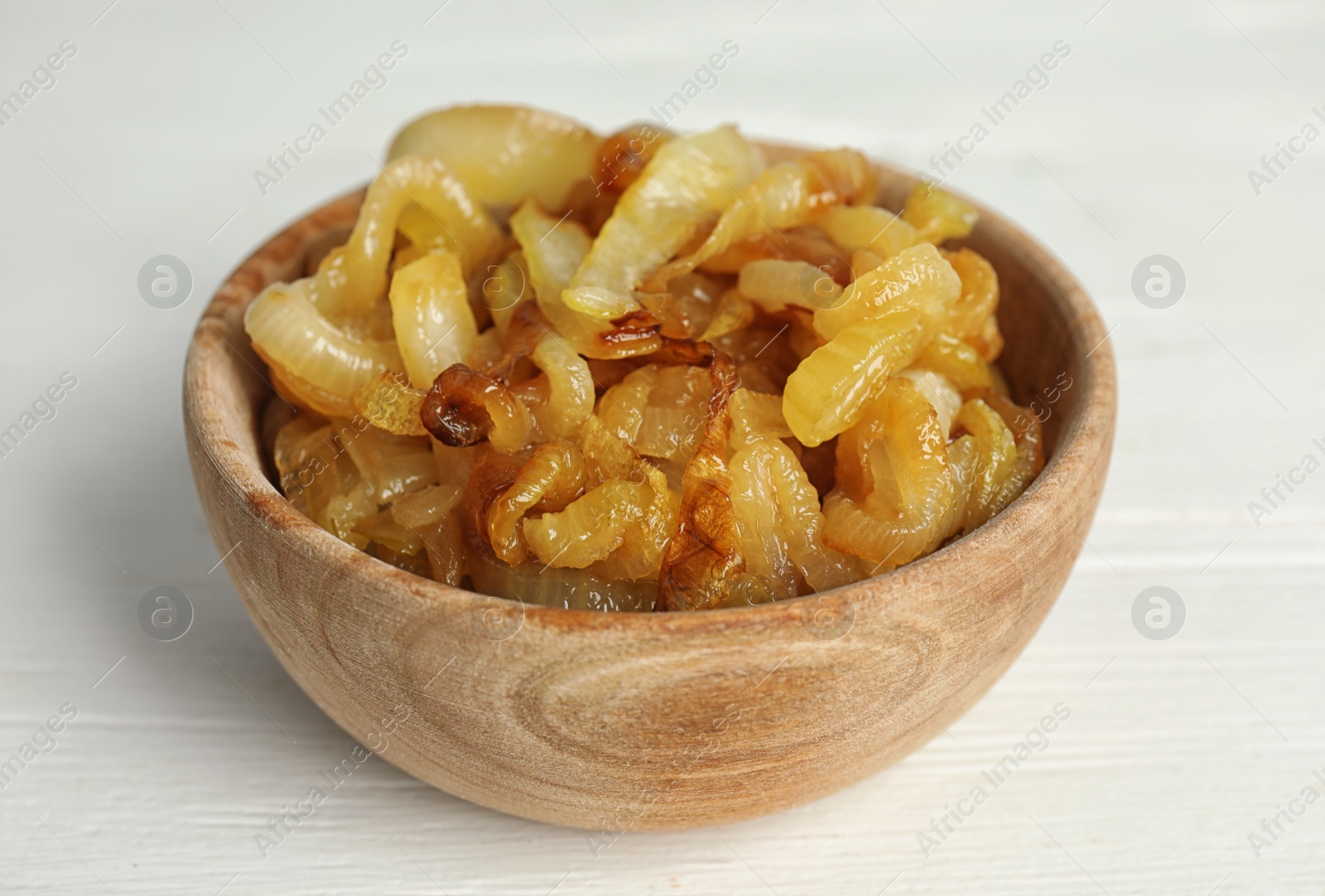 Photo of Tasty fried onion on white wooden table, closeup