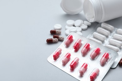 Photo of Different antidepressants and medical bottle on grey background, closeup. Space for text