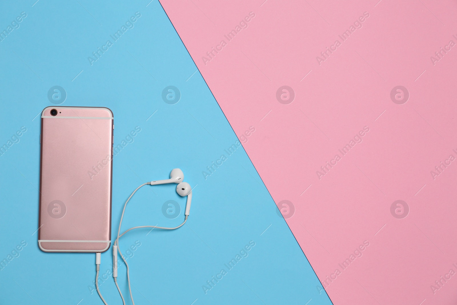 Photo of Modern smartphone with earphones on color background, top view. Space for text