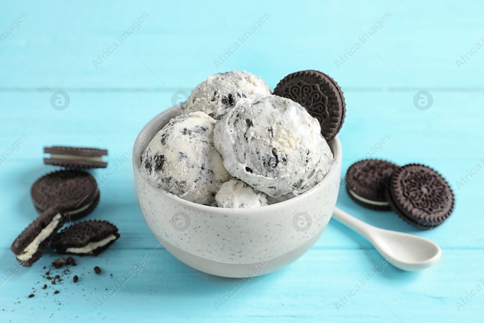 Photo of Bowl with ice cream and crumbled chocolate cookies on wooden background
