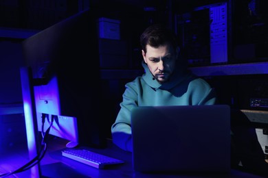 Photo of Hacker working with computers in dark room. Cyber attack