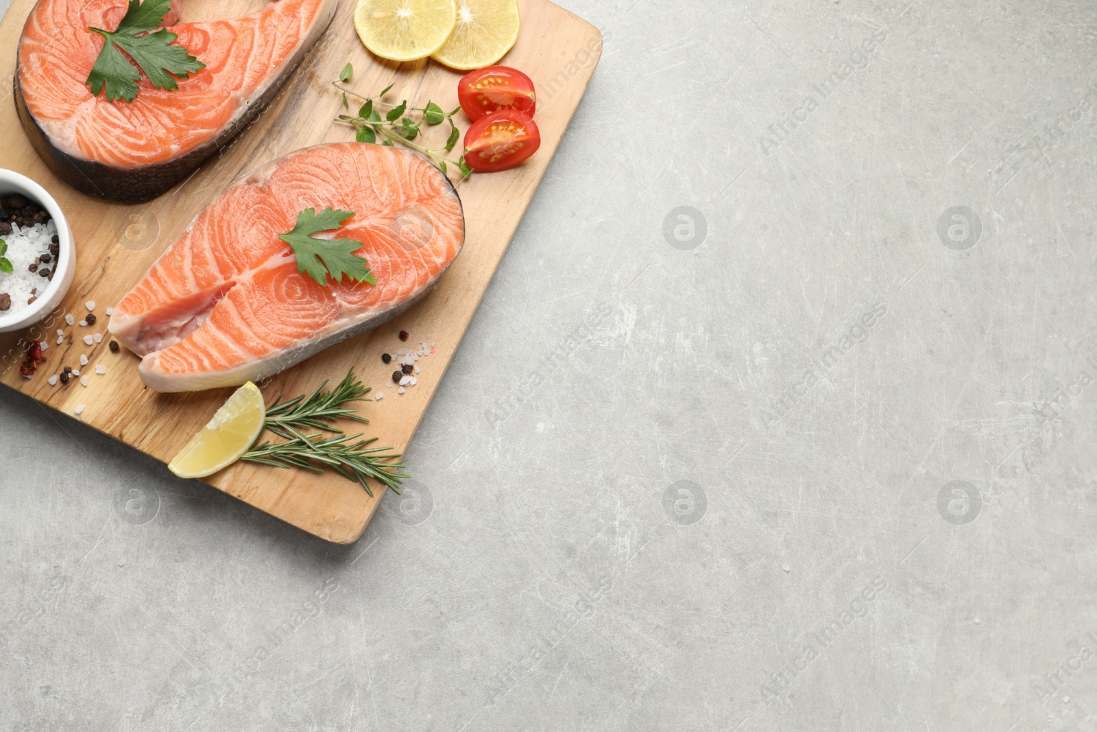 Photo of Fresh salmon and ingredients for marinade on light grey table, top view. Space for text