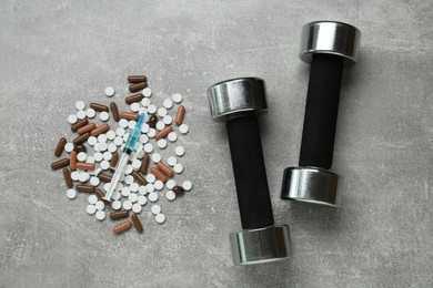 Photo of Different drugs and sports equipment on grey table, flat lay. Doping control