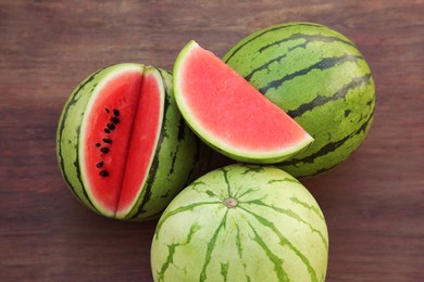 Different delicious ripe watermelons on wooden table, above view
