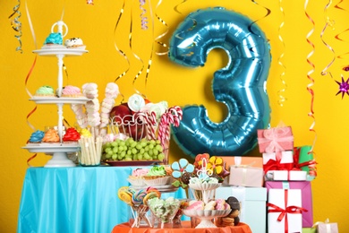 Photo of Dessert table in room decorated with blue balloon for 3 year birthday party