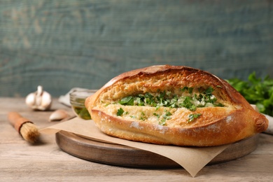 Photo of Delicious homemade garlic bread with herbs on wooden table