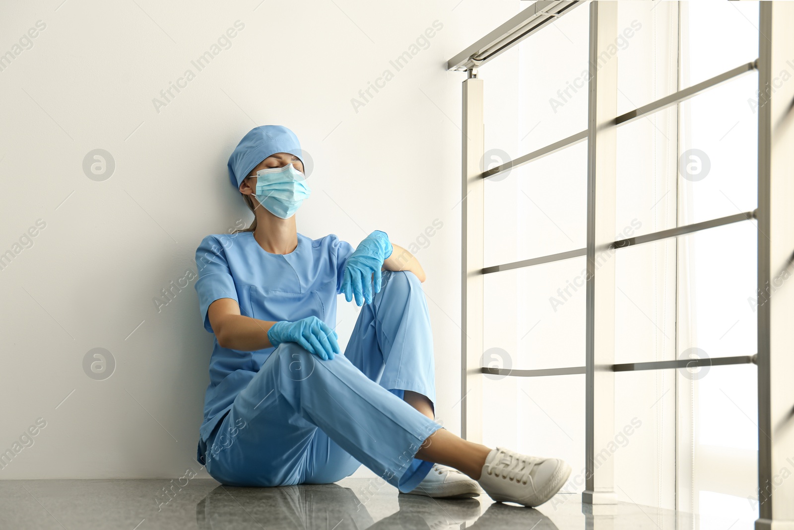 Photo of Exhausted doctor indoors. Stress of health care workers during COVID-19 pandemic