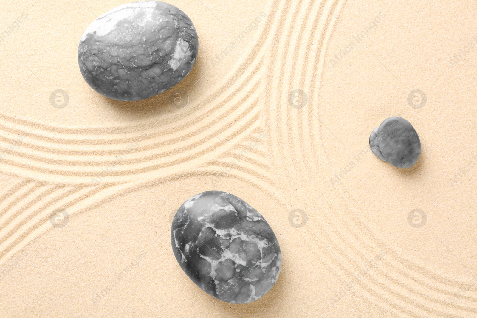 Photo of Zen concept. Stones and pattern on beige sand, flat lay