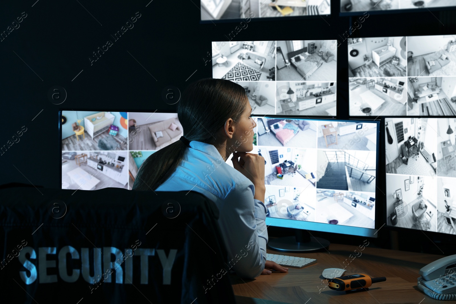 Photo of Security guard monitoring modern CCTV cameras indoors at night