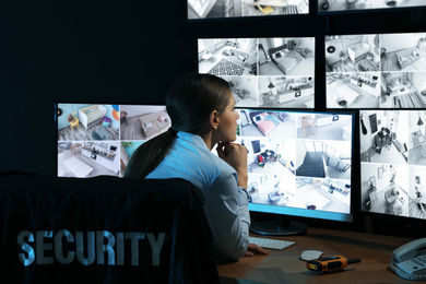 Photo of Security guard monitoring modern CCTV cameras indoors at night