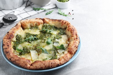 Delicious pizza with pesto, cheese and arugula on grey table