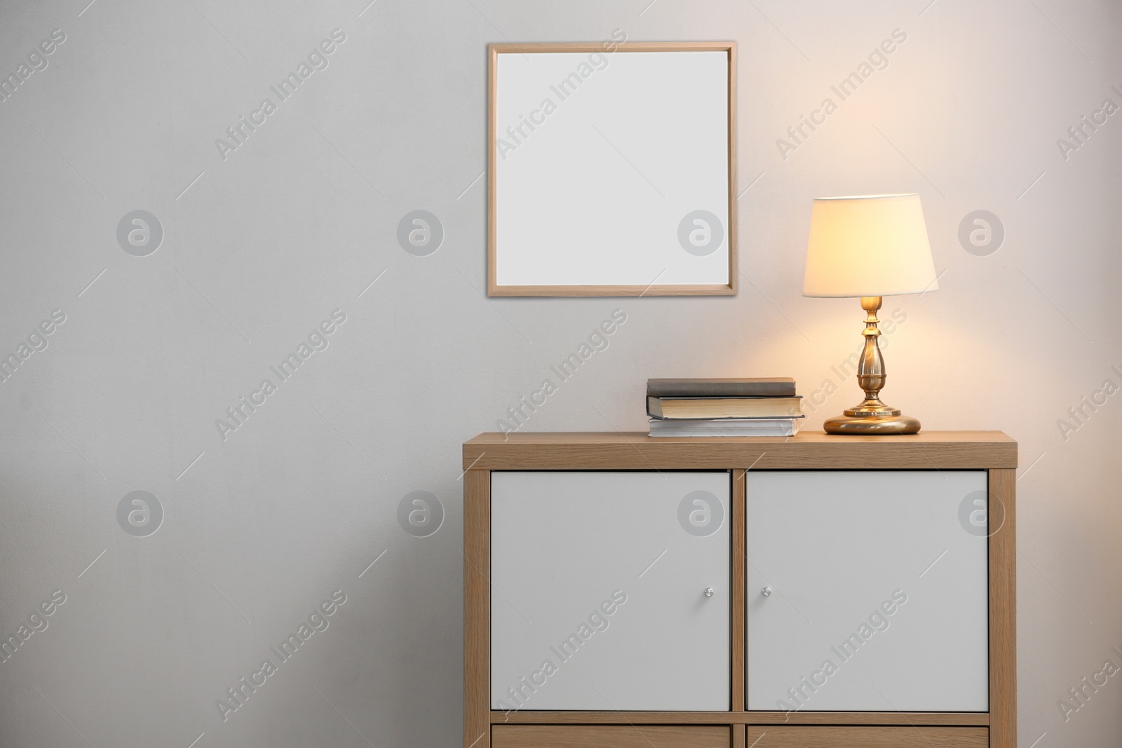 Image of Stylish cabinet near wall with empty poster