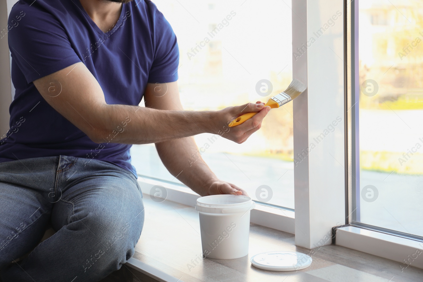 Photo of Man painting window frame at home, closeup