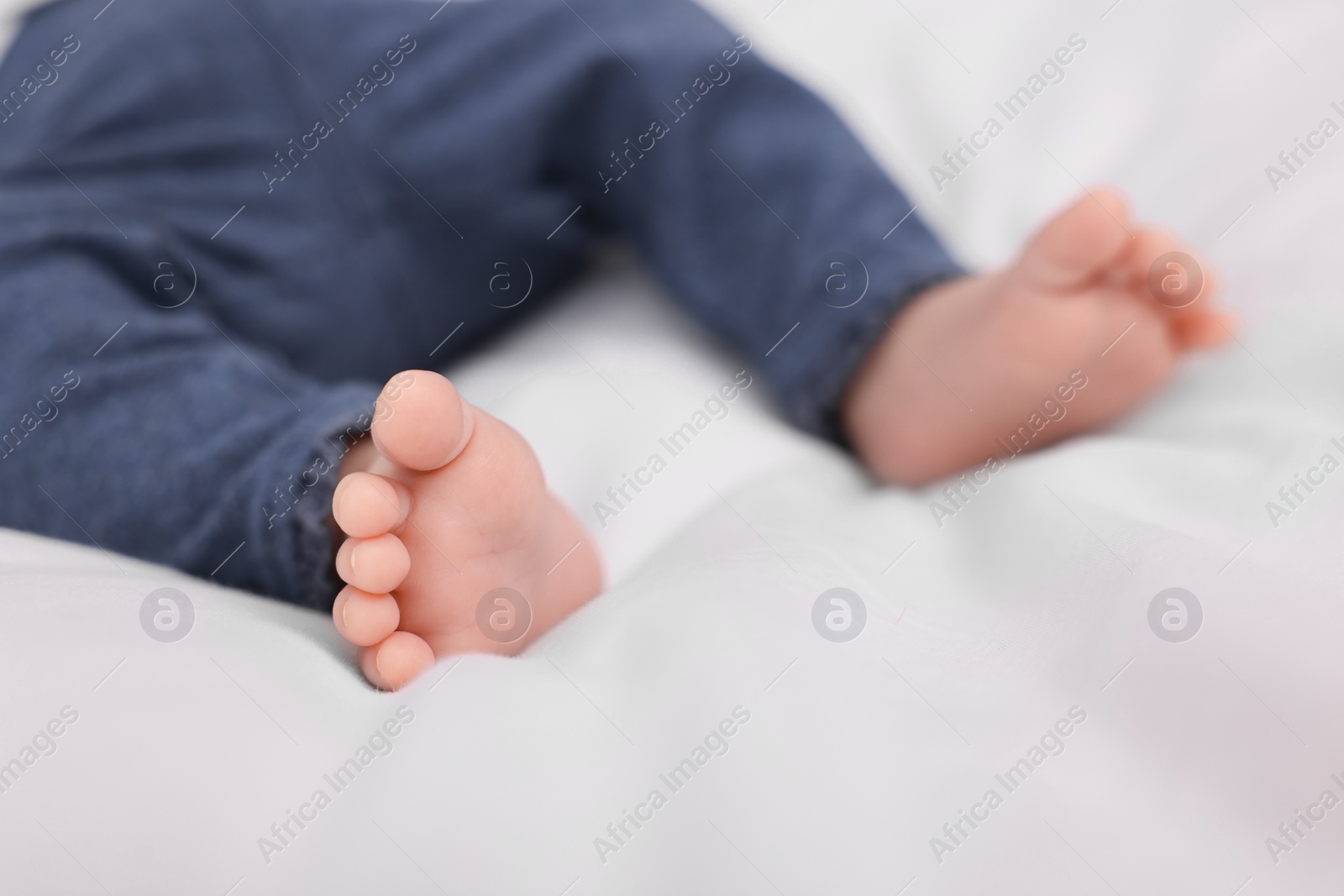 Photo of Newborn baby lying on white blanket, closeup