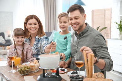 Happy family enjoying fondue dinner at home