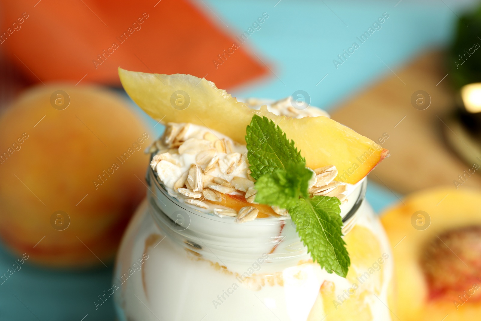 Photo of Tasty peach dessert with yogurt and granola on table, closeup