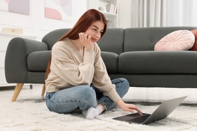 Photo of Beautiful woman using laptop in living room