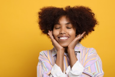 Portrait of smiling African American woman on orange background