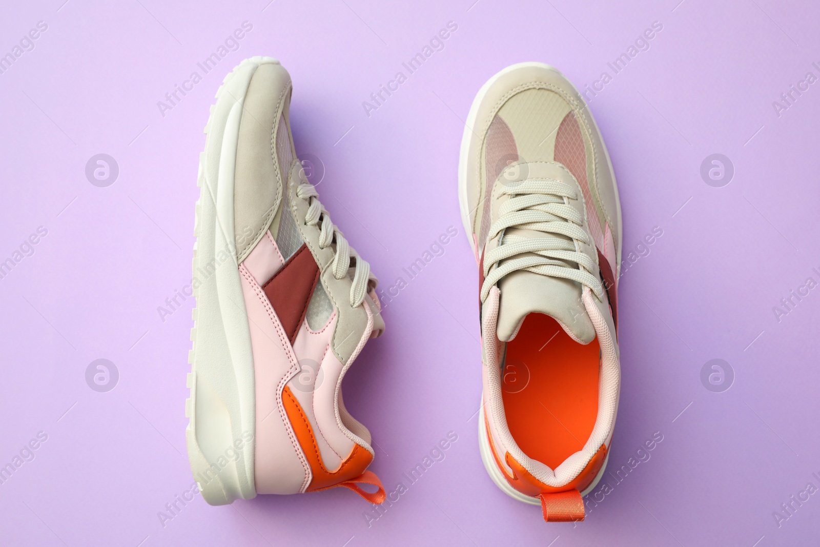 Photo of Pair of stylish shoes on lilac background, top view