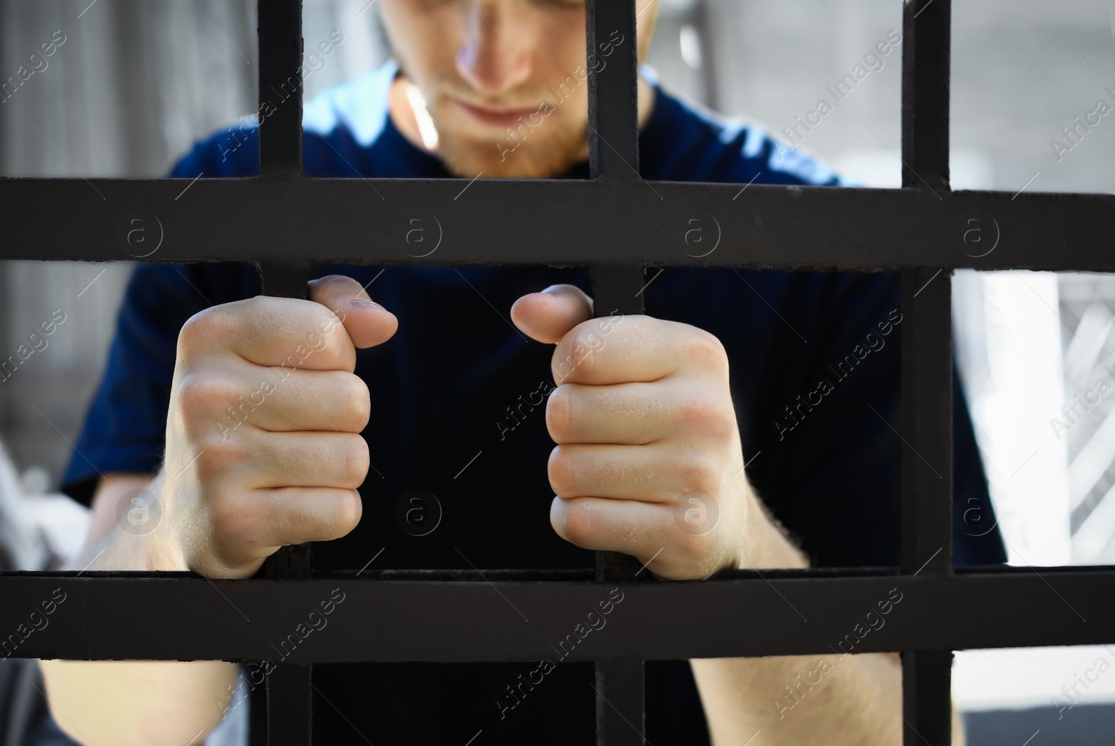 Photo of Man detained in jail outdoors, closeup. Criminal law